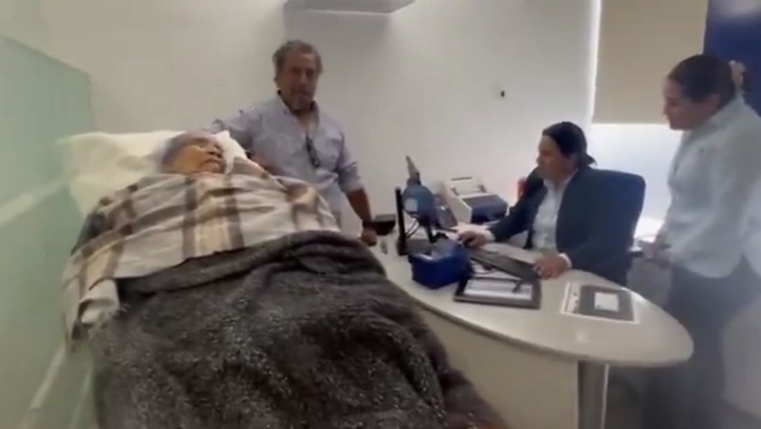 Banco obliga a una ancianita a ir en camilla